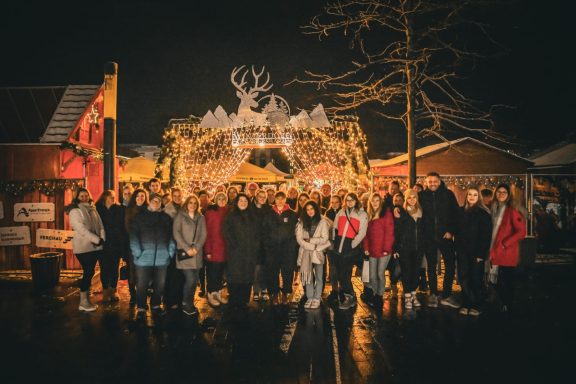 Gruppenszene vor festlicher Beleuchtung in einer winterlichen Landschaft.
