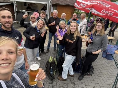Gruppenfoto von Menschen, die zusammen Bier trinken und fröhlich posieren.