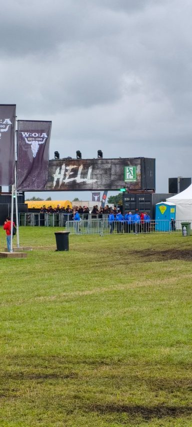 Graues Himmel, Festivalgelände mit Zelten und Werbung im Hintergrund.